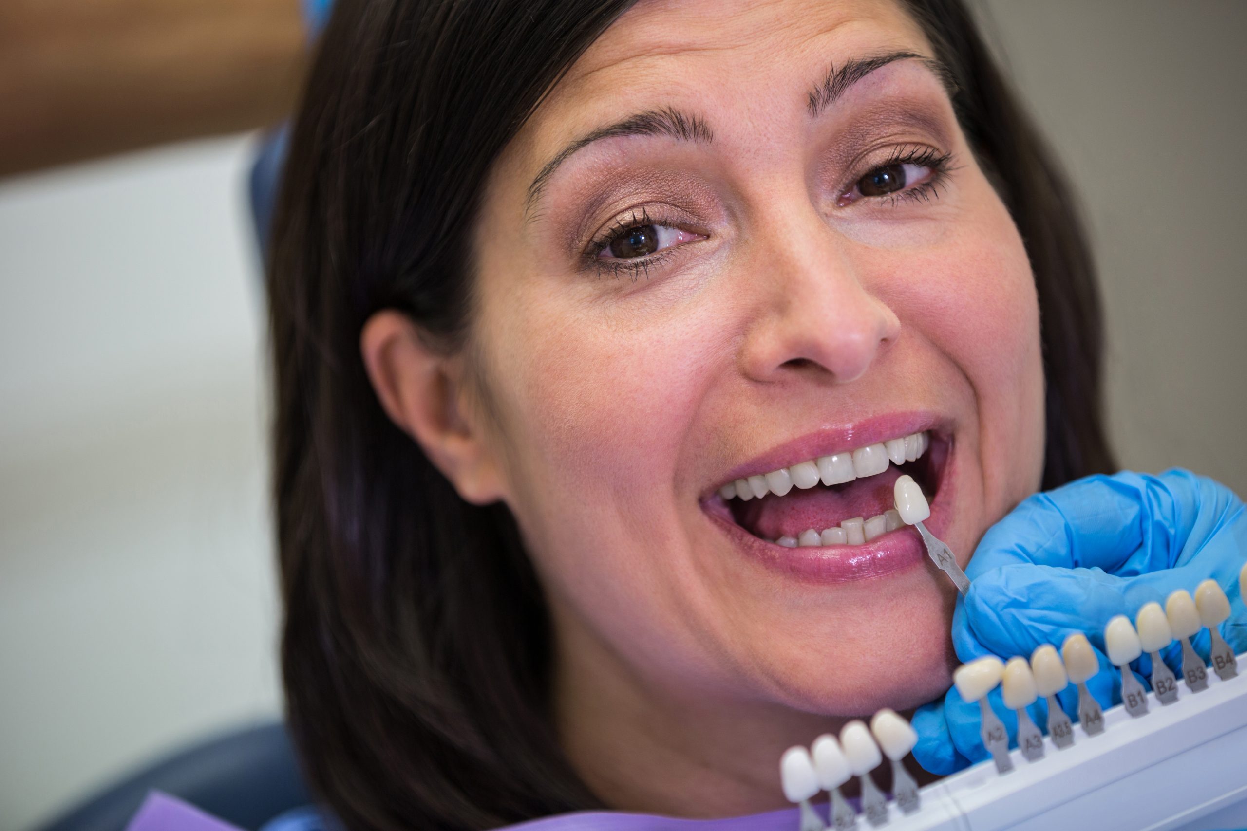 dentist examining female patient with teeth shades scaled